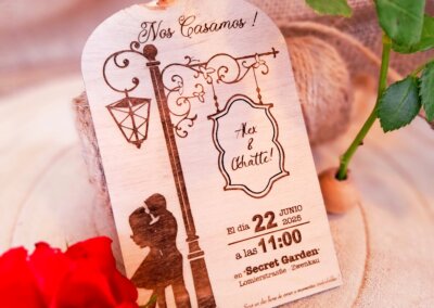 Hölzerne Hochzeitseinladung 'Paris_Romantic' mit romantischem Vintage-Design: Liebespaar unter einer Laterne, filigrane Verzierungen und elegante Schrift. Datum und Ort der Zeremonie in warmen, romantischen Tönen.