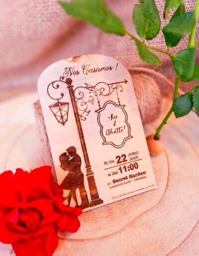 Hölzerne Hochzeitseinladung 'Paris_Romantic' mit romantischem Vintage-Design: Liebespaar unter einer Laterne, filigrane Verzierungen und elegante Schrift. Datum und Ort der Zeremonie in warmen, romantischen Tönen.